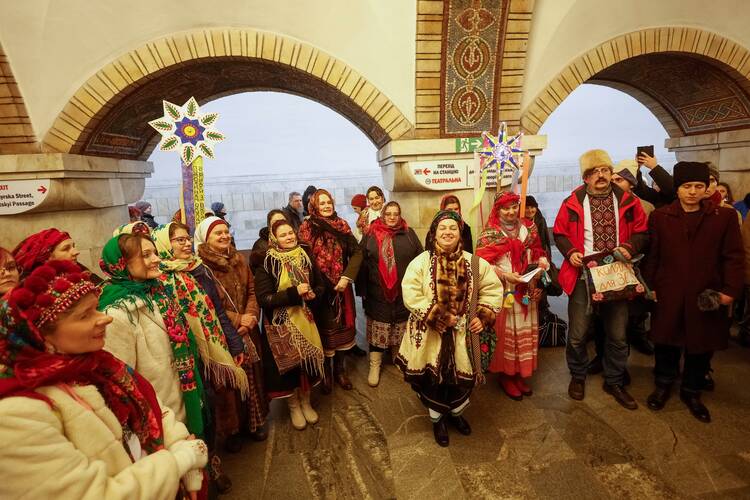 Local residents sing Christmas carols during an air raid alarm inside a metro station in Kyiv, Ukraine.