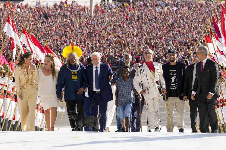 Luiz Inacio Lula da Silva arrives to the Planalto Palace with a group representing diverse segments of society after he was sworn in as new president in Brasilia, Brazil, Sunday, Jan. 1, 2023. (AP Photo/Eraldo Peres)