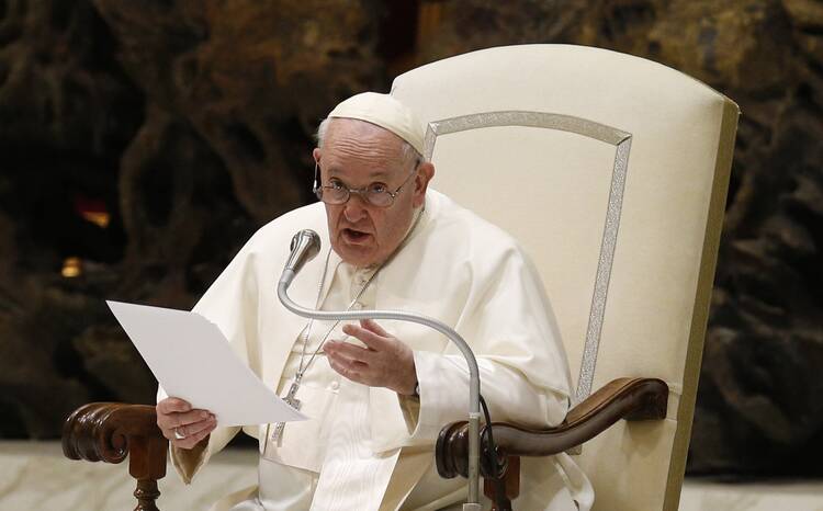 pope francis sits in his chair and gestures during his general audience