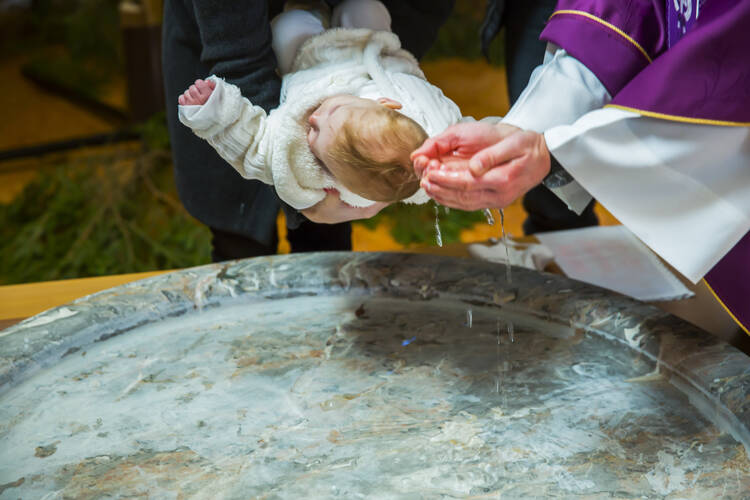 priest baptizing a baby girl