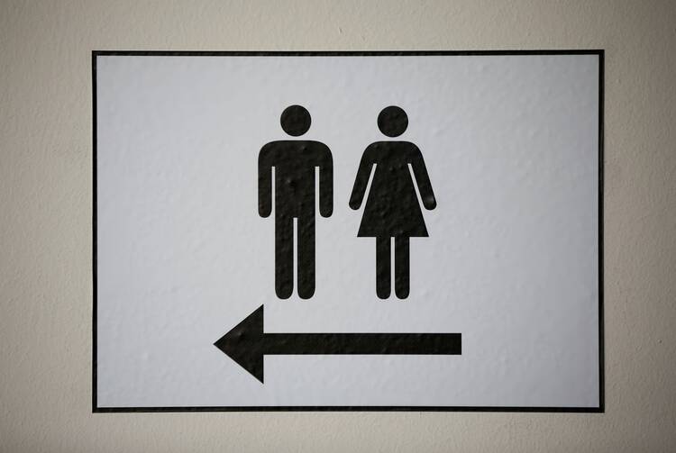 A sign illustrates men's and women's restrooms.