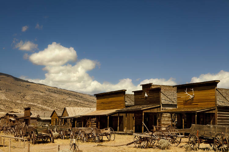 an old west town with blue sky and brown buildings