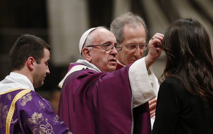 Pope Francis gives ashes to a woman as he celebrates Ash Wednesday Mass in St. Peter's Basilica at the Vatican.