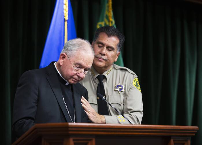 Los Angeles County Sheriff Robert Luna comforts Los Angeles Archbishop José H. Gomez while he speaks during a Feb. 20, 2023, news conference after the arrest of 61-year-old Carlos Medina, the suspect in the murder of Auxiliary Bishop David G. O'Connell.