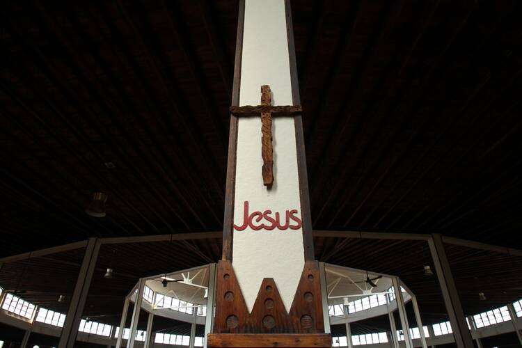 a cross with jesus' name under it on a pillar at the church at our lady of martyrs shrine in auriesville
