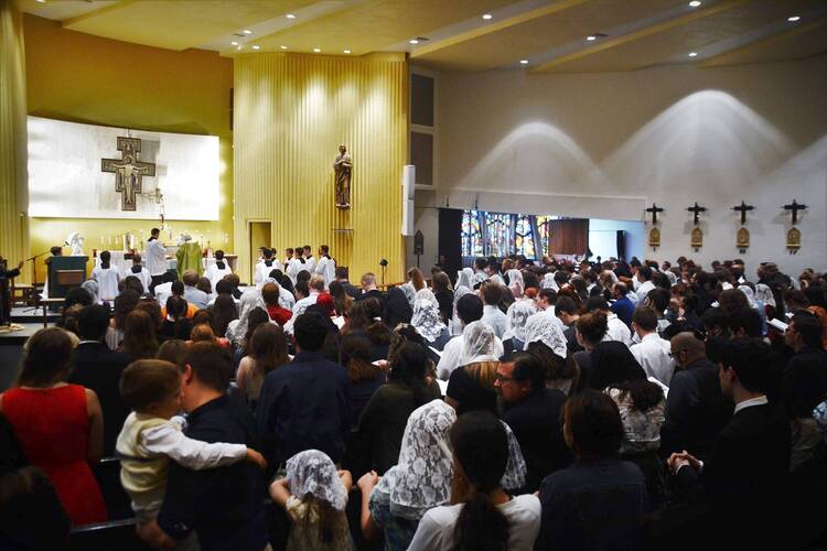 A crowd faces the altar of a church