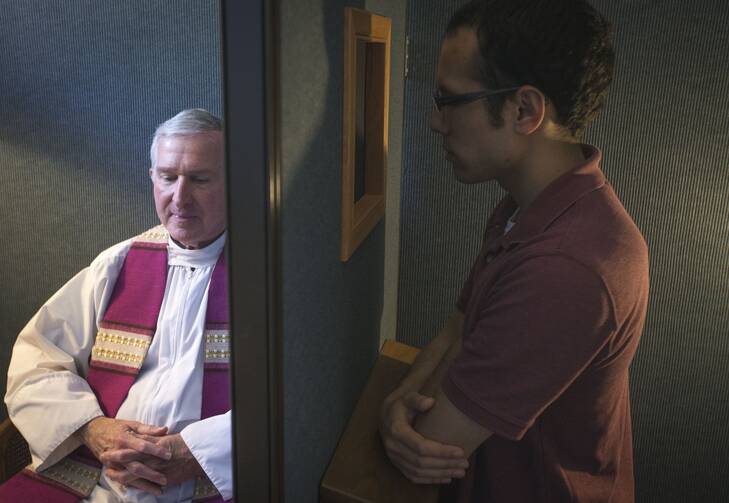 Father Timothy J. Mockaitis, pastor of Queen of Peace Church in Salem, Ore., and penitent Ethan K. Alano of Salem demonstrate how a confession is conducted.