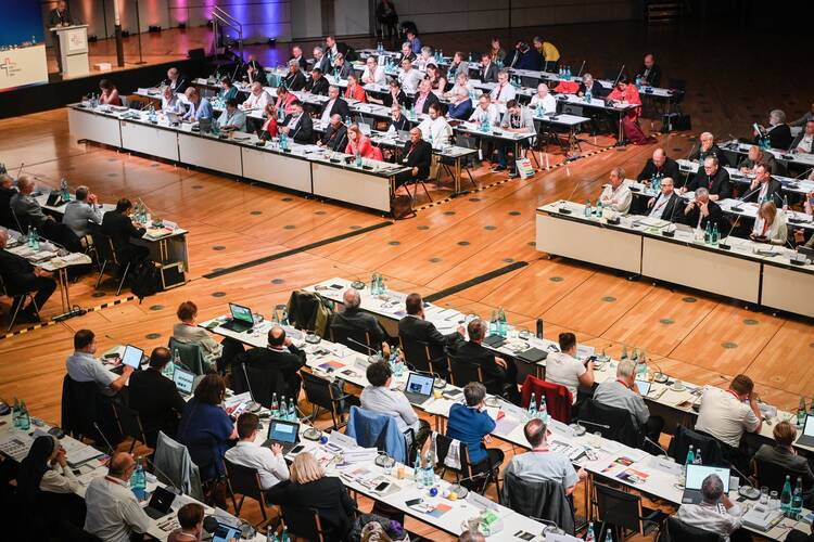 people sitting at desks in a large conference room