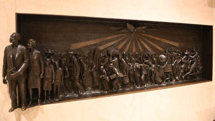 a bas relief sculpture of black people from slavery to emancipation with holy spirit above them