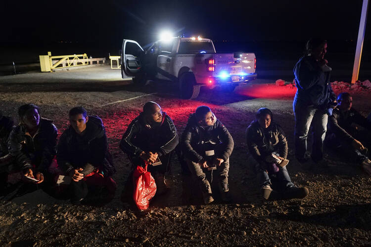 Migrants wait to be processed after crossing the border on Jan. 6, 2023, near Yuma, Ariz. The Biden administration says it will generally deny asylum to migrants who show up at the U.S. southern border without first seeking protection in a country they passed through. (AP Photo/Gregory Bull, File)
