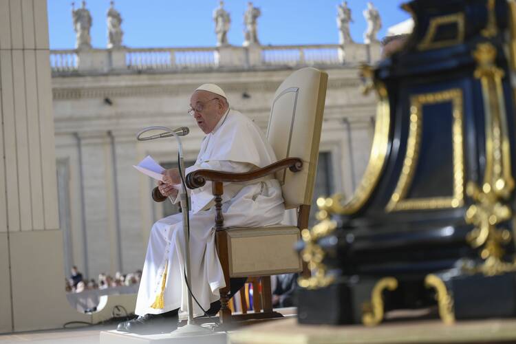pope francis sits in his chair at the general audience