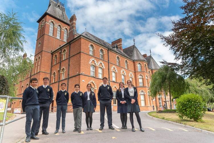 Irish children in Catholic school uniforms stand in front of their school