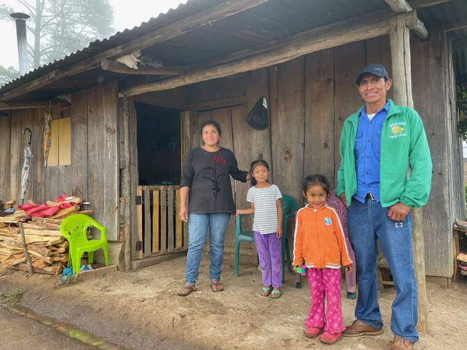 A family stands in front of their home in Honduras