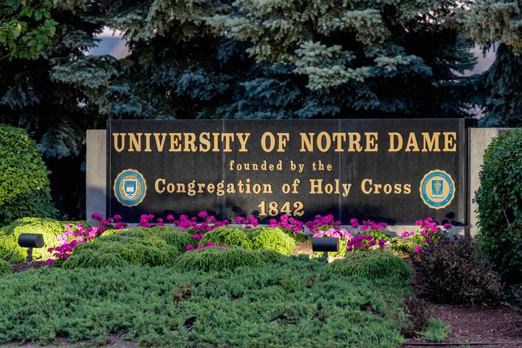 for an article about reproductive justice lectures, the welcome sign outside university of notre dame with the school's name and congregation of the holy cross beneath it