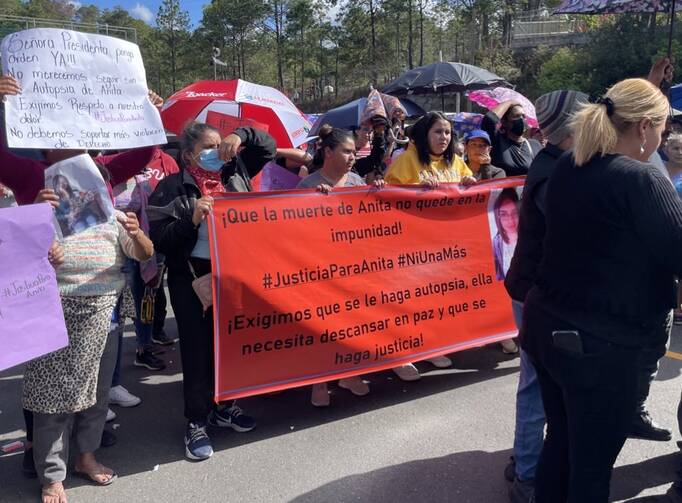 Several honduran women hold a large red sign calling for justice for Ana Lizeth Hernández