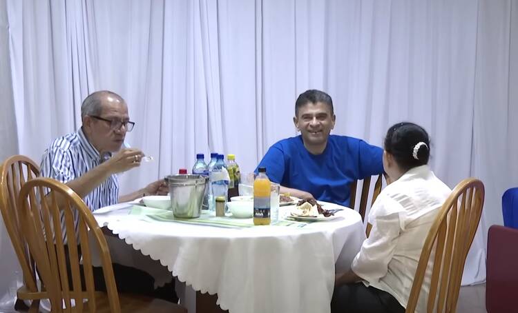 A family sits around a table eating a meal