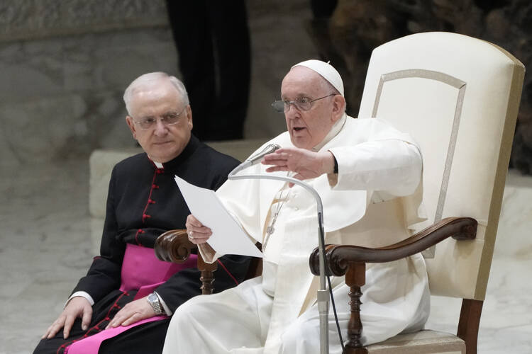 pope francis sits whiles delivering a speech in the Paul VI Hall at the Vatican