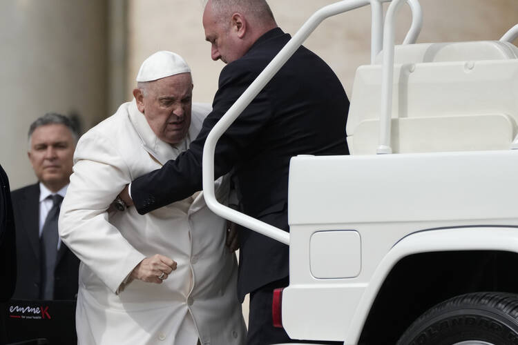 pope francis helped by a man in black to get into a car