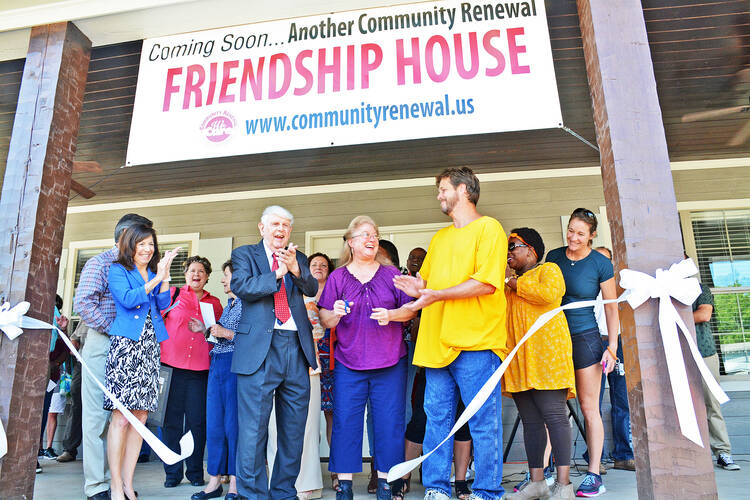 Members of Community Renewal International at a ribbon-cutting ceremony on the front porch of its 10th Friendship House on Sept. 15, 2017, in the Highland neighborhood of Shreveport, La. (Photo courtesy of Community Renewal International)