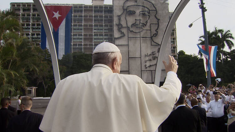Pope Francis waving to the crowd in front of a depiction of Che Guevera in Havana, Cuba
