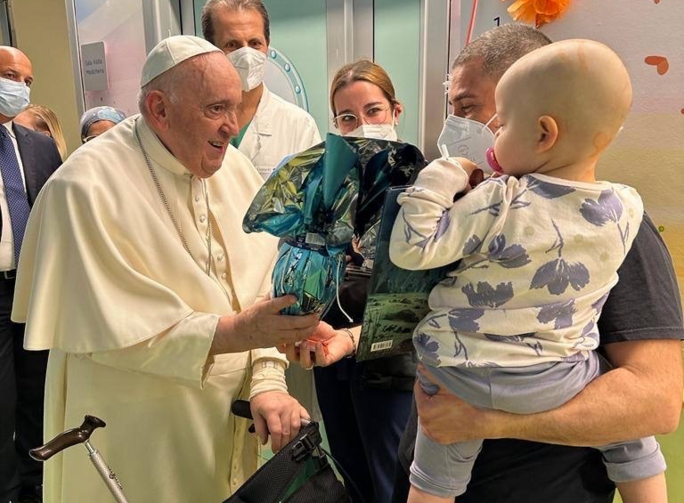 pope francis greets a baby held by his mother