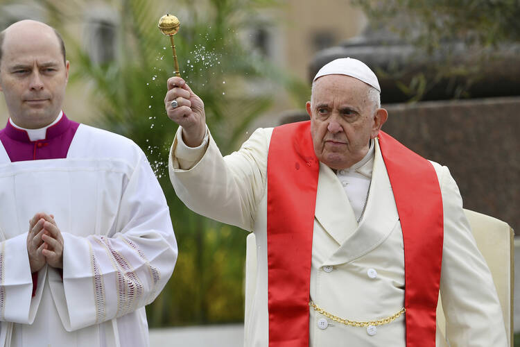 Pope Francis blesses the palm branches before celebrating the Palm Sunday Mass in St. Peter's Square at the Vatican on April 2, 2023, a day after being discharged from the Agostino Gemelli University Hospital in Rome, where he has been treated for bronchitis. (AP Photo/Filippo Monteforte, pool)