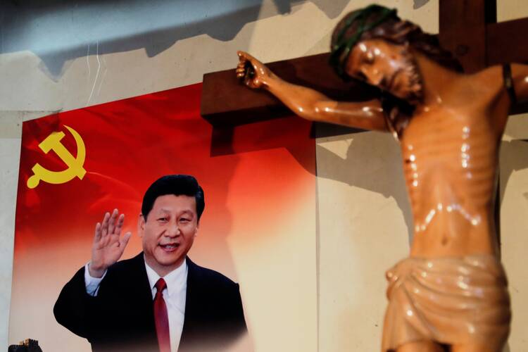 A crucifix in front of a poster of Chinese President Xi Jinping.
