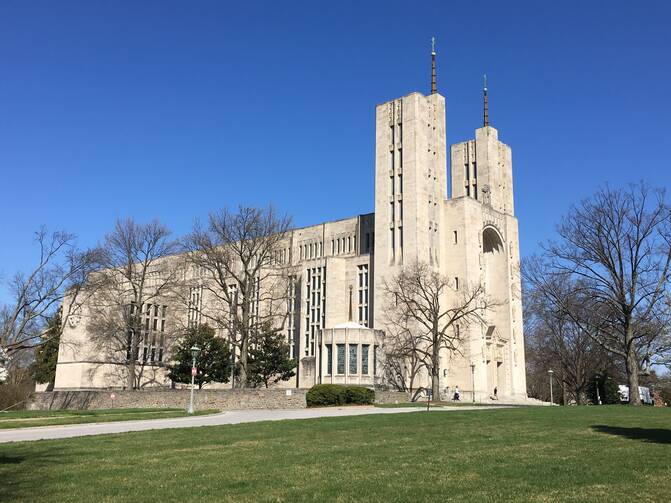 cathedral of mary our queen in baltimore with green grass and a blue sky above it