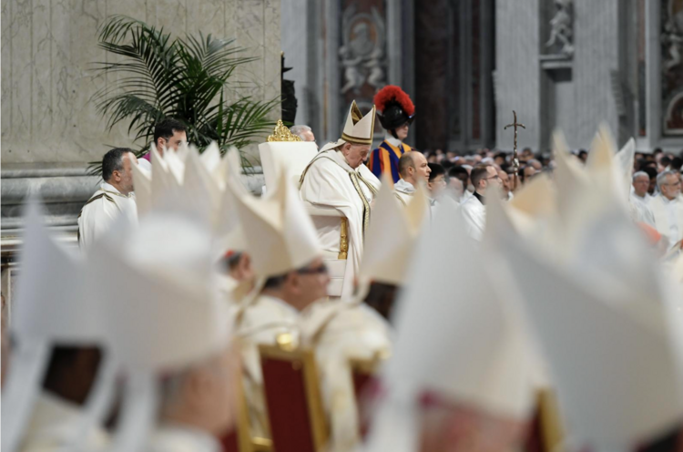 Pews full of Catholic priests wearing religious garb sitting in a church