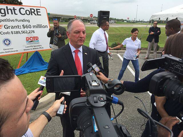 A politician in a suit answers media questions