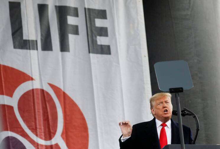 donald trump stands in front of a pro life sign speaking at the march for life in 2020