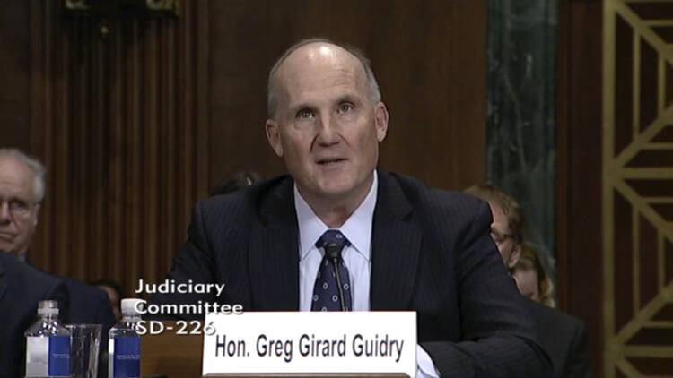 A Louisiana politician speaks into a mic, identified as Greg Guidry