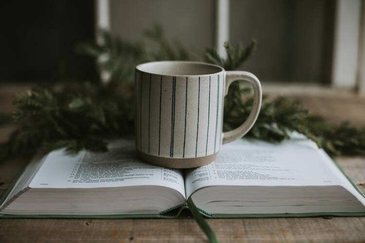 book open with coffee mug sitting atop it