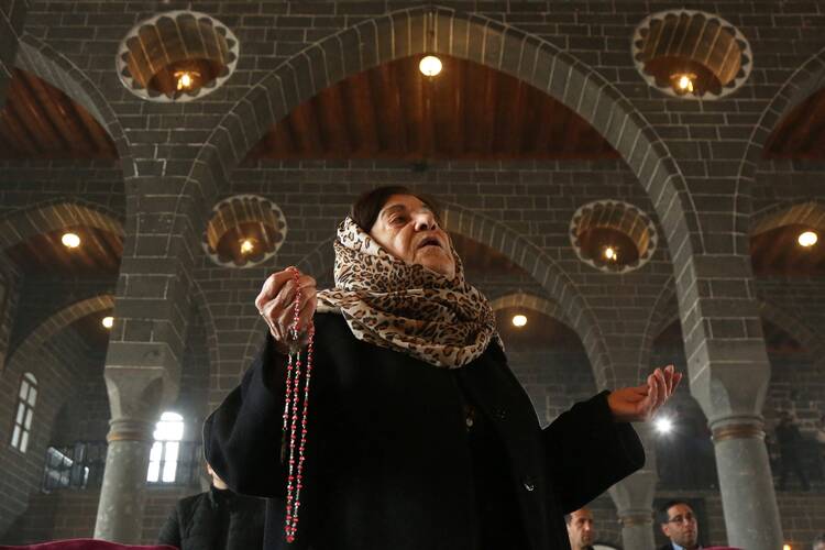 A woman prays during an Easter Sunday Mass at Surp Giragos Armenian Catholic Church in Diyarbakir, Turkey, April 9, 2023. (OSV News photo/Sertac Kayar, Reuters)