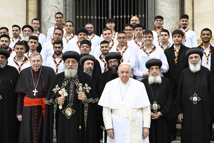 pope francis stands next to coptic orthodox pope tawadros ii, they stand in front of a bunch of men in priestly clothing