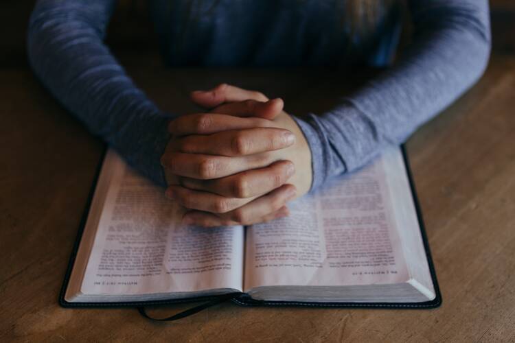 Man holding hands on Bible