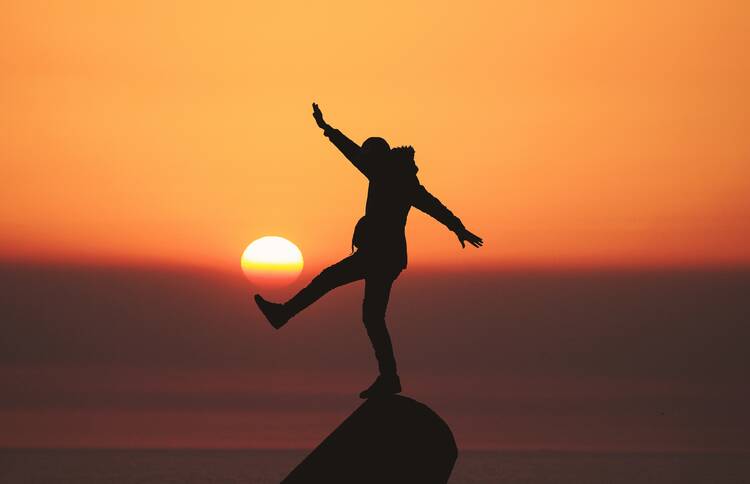 Silhouette of man standing on rock