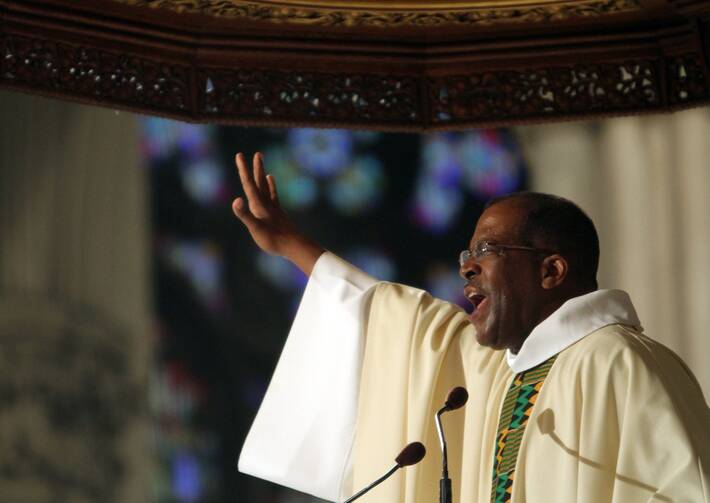 Greg Chisholm, S.J., gestures while giving a homily