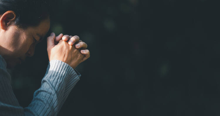 person praying with folded hands