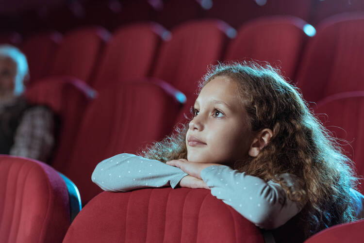 Photo of a girl watching a film in a movie theater
