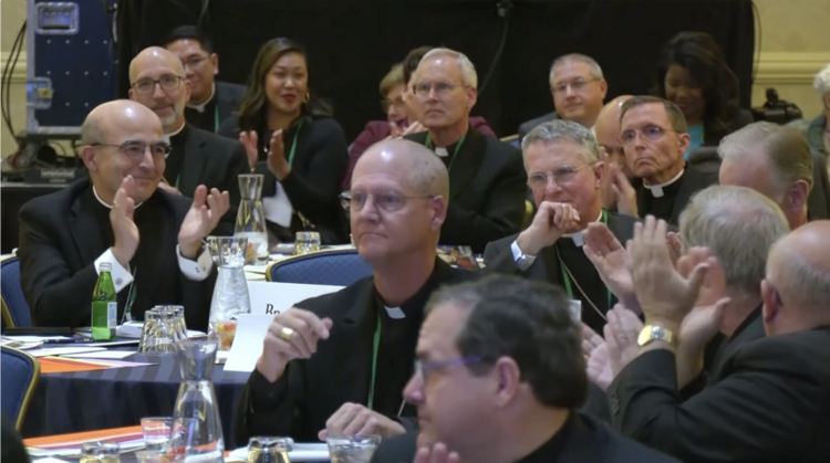 Catholic priests sit at tables for meeting