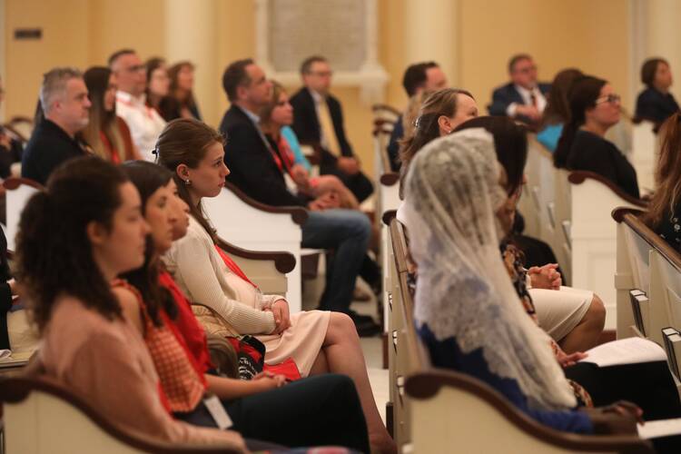 people sit in a church at the catholic media conference