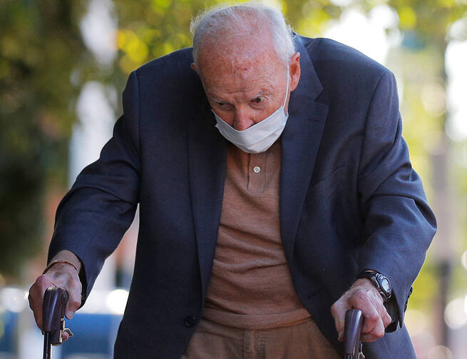 Former Cardinal Theodore E. McCarrick uses a walker with a mask on.