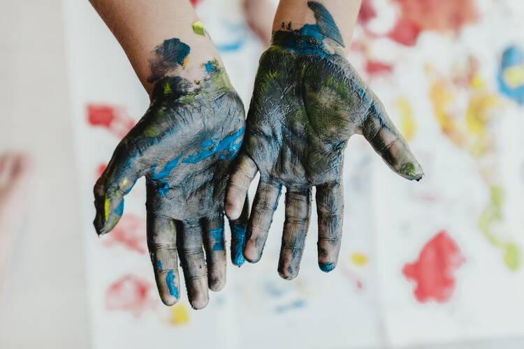 Two hands covered in paint