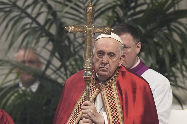 Pope Francis carries a cross. 
