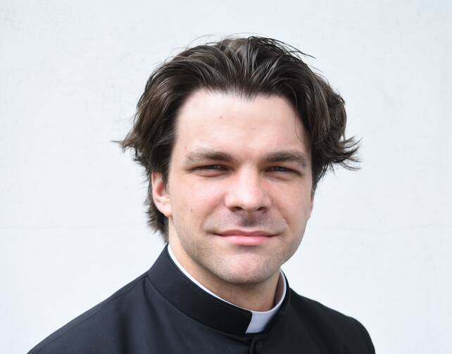 Headshot of Father Alex Crow, young white brunette man in collar