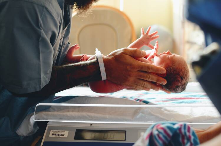 person holding baby on scale