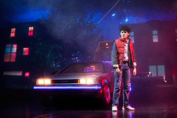 Casey Likes as Marty McFly in ‘Back to the Future’ on Broadway, pictured in a red vest and standing in front of a DeLoreon (photo: Matthew Murphy and Evan Zimmerman)