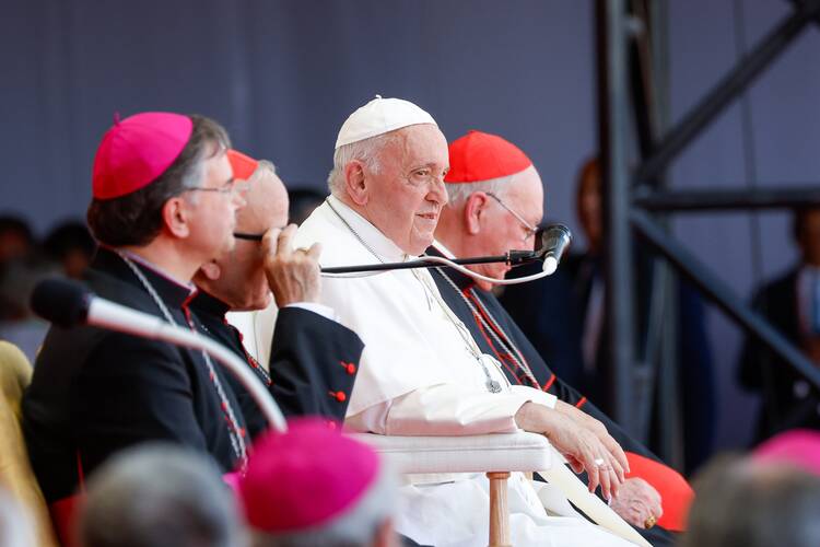 Pope Francis listens to World Youth Day volunteers share their reflections at a concert venue in Algés, Portugal, Aug. 6, 2023.