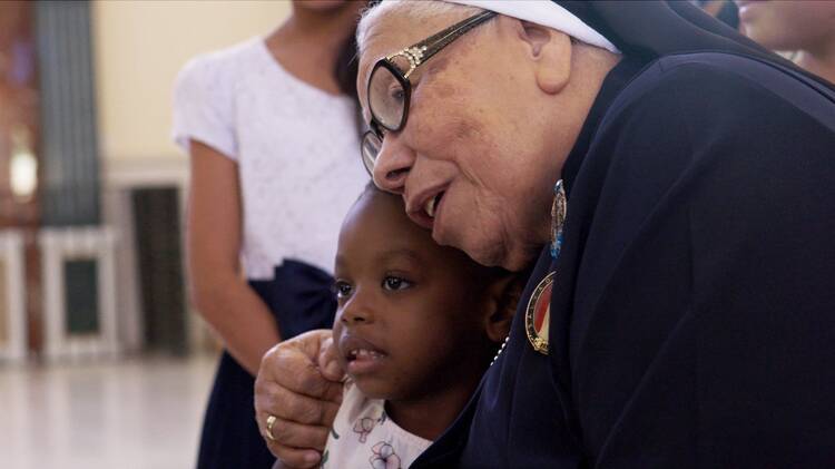 Sister Maria Rosa Leggol, a Franciscan sister who some call the "Mother Teresa of the Honduras" is shown hugging a child in this image taken from the documentary "With This Light." (OSV News photo/courtesy Miraflores Films)
